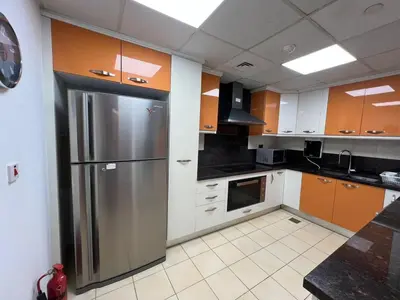 a large kitchen with a stainless steel refrigerator at Luxurious JBR Beach Facing 4BHK in Dubai