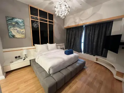 a bedroom with a bed and a couch and a chandelier at Luxurious JBR Beach Facing 4BHK in Dubai