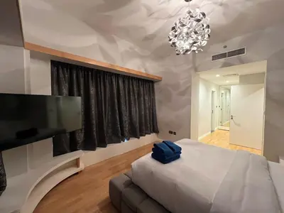 a bedroom with a large bed and a flat screen tv at Luxurious JBR Beach Facing 4BHK in Dubai