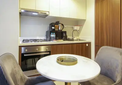 a small kitchen with a white table and chairs at Wecation Damac Vera - Business Bay in Dubai