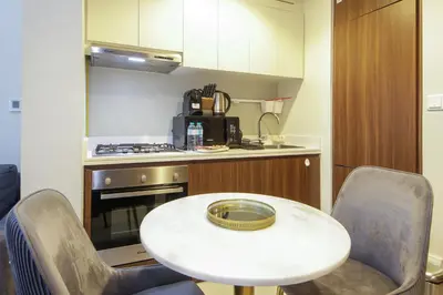 a small kitchen with a white table and chairs at Wecation Damac Vera - Business Bay in Dubai
