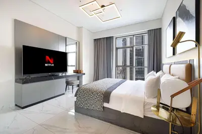 a bedroom with a bed and a tv in a room at MajeStay - MAG Living in Dubai