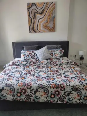 a bed with a floral comforter and pillows at Ahlan Premium Luxury Marina Cityview JBR in Dubai