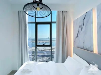 a bedroom with a bed and a large window at Luxury One Bedroom with Balcony & partial Burj Khalifa View in Dubai