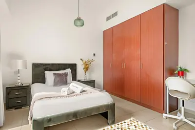 a bedroom with a bed and a cabinet and a chair at JBR Beach 2Bed Apartment with Full Marina View in Dubai