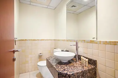 a bathroom with a sink and a toilet and a mirror at JBR Beach 2Bed Apartment with Full Marina View in Dubai