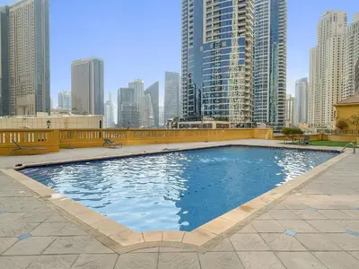 a large swimming pool in a city with tall buildings at JBR Beach 2Bed Apartment with Full Marina View in Dubai