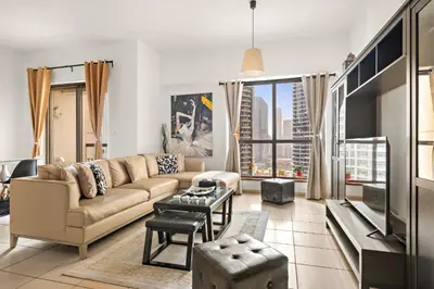 a living room with a couch and a tv at JBR Beach 2Bed Apartment with Full Marina View in Dubai