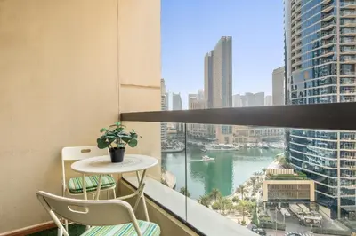 a balcony with a table and chairs and a view of a river at JBR Beach 2Bed Apartment with Full Marina View in Dubai