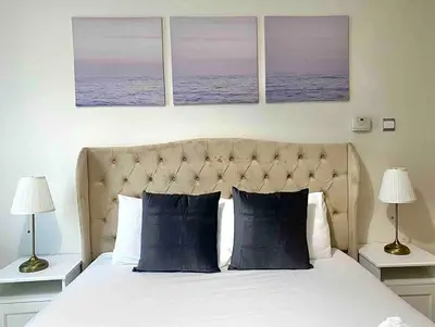a bedroom with a bed with three paintings on the wall at lovely Studio in Dubai Marina near beach Z1009 in Dubai