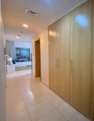 a hallway with wooden cabinets and a living room at lovely Studio in Dubai Marina near beach Z1009 in Dubai