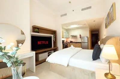 a bedroom with a white bed and a television at Studio in Dubai Marina near beach and Metro Z514 in Dubai