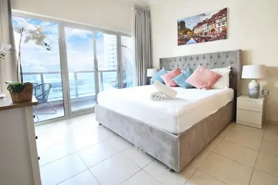 a bedroom with a large bed and a large window at 1Bedroom Apartment in Dubai Marina near to beach & Metro Z1006 in Dubai