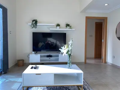 a living room with a white coffee table and a tv at 1Bedroom Apartment in Dubai Marina near to beach & Metro Z1006 in Dubai
