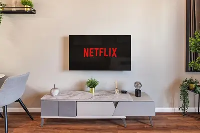 a living room with a netflix sign on the wall at Stunning studio at sports city in Dubai