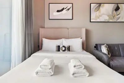 a hotel room with a bed with towels on it at Stunning studio at sports city in Dubai