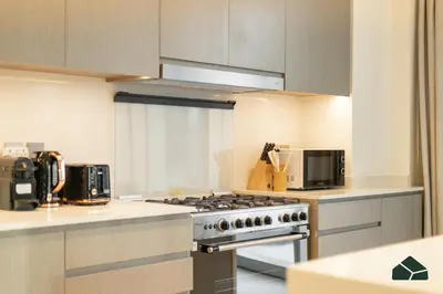 a kitchen with a stove and a microwave at Grande Signature Deluxe Next to Dubai Opera by BMS in Dubai