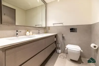 a bathroom with two sinks and a toilet and a mirror at Grande Signature Deluxe Next to Dubai Opera by BMS in Dubai