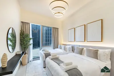 a bedroom with two beds and a large window at Grande Signature Deluxe Next to Dubai Opera by BMS in Dubai