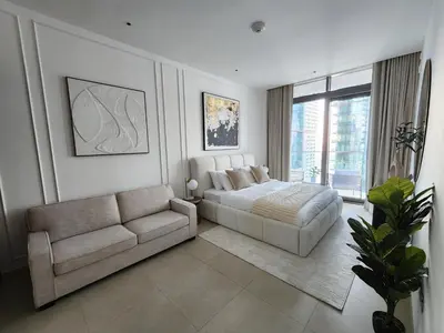 a white bedroom with a bed and a couch at SOLARTE Luxe - Marina Gate - Spectacular Pools with Marina Views in Dubai