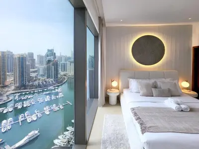 a bedroom with a bed and a view of a harbor at SOLARTE Luxe - Marina Gate - Spectacular Pools with Marina Views in Dubai