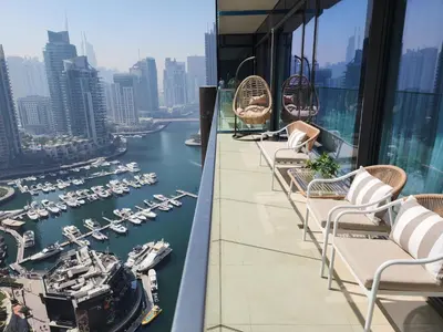 a balcony with chairs and a view of a harbor at SOLARTE Luxe - Marina Gate - Spectacular Pools with Marina Views in Dubai