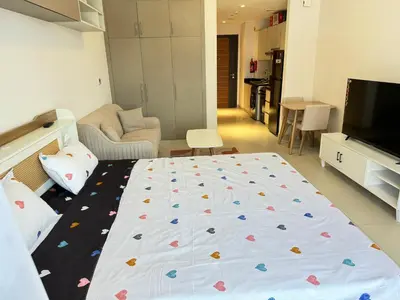 a bedroom with a bed and a living room at Spacious Studio with Burj Khalifa Views in Dubai