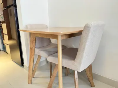 a wooden table with two chairs around it at Spacious Studio with Burj Khalifa Views in Dubai