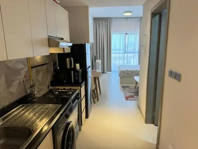 a kitchen with a sink and a stove top oven at Spacious Studio with Burj Khalifa Views in Dubai