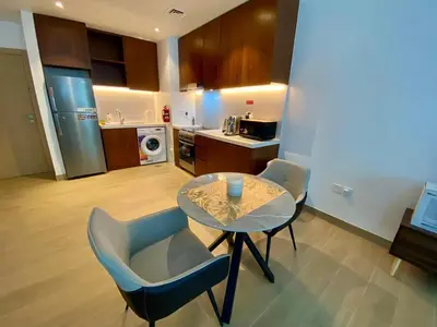 a kitchen with a table and two chairs and a table at La Mer Beach Jumeirah 1 bedroom hall Beach view balcony burj khalifa view walk distance few steps by oima leasing property in Dubai