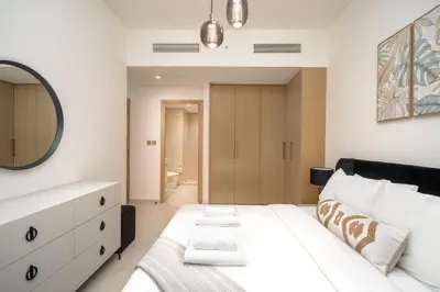 a bedroom with a white bed and a mirror at BURJ ROYALE - Full Burj Khalifa & Fountain Views - LUXE Apartment in Dubai