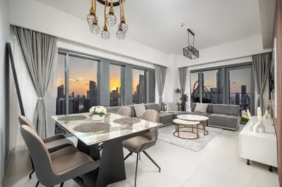 a living room with a table and chairs and a large window at BURJ ROYALE - Full Burj Khalifa & Fountain Views - LUXE Apartment in Dubai