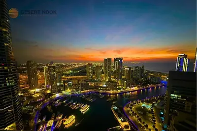 a view of a city at night with a river at Best Location Marina & Sea View 1 min from JBR in Dubai