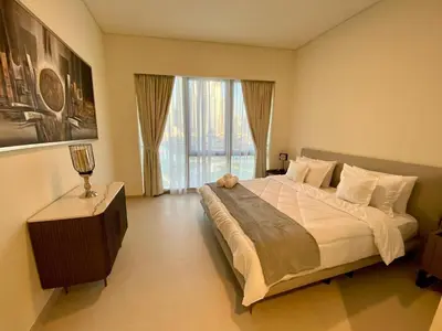 a bedroom with a large bed and a large window at Grande signature residence Smart Burj khalifa Fountains view large 3 bedroom hall 4 bathroom view burj khalifa Fountains from hall and rooms balcony in Dubai