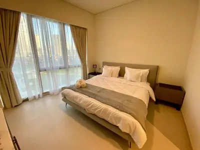 a bedroom with a large bed with a teddy bear on it at Grande signature residence Smart Burj khalifa Fountains view large 3 bedroom hall 4 bathroom view burj khalifa Fountains from hall and rooms balcony in Dubai