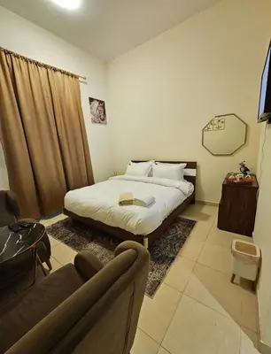 a bedroom with a bed and a couch in it at Room with bathroom near beach walk la mer beach Oima leasing property in Dubai