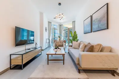 a living room with a couch and a tv at Exclusive Promo Modern 1BR with Partial Canal Views by Deluxe Holiday Homes in Dubai