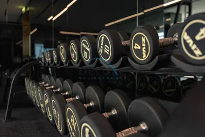 a row of dumbbells in a gym at Exclusive Promo Modern 1BR with Partial Canal Views by Deluxe Holiday Homes in Dubai