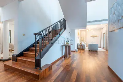 a staircase in a home with white walls and wood floors at Beach Access Villa with Backyard in Prime Location in Canal Cove, Palm Jumeirah by Deluxe Holiday Homes in Dubai