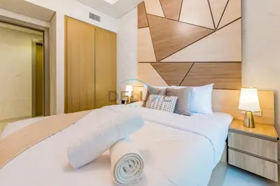 a bedroom with a large white bed with a wooden headboard at Limited Time Offer Tranquil 1BR in Business Bay by Deluxe Holiday Homes in Dubai
