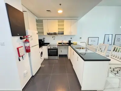 a kitchen with white appliances and a white refrigerator at Dubai damac hills luxurious appartment in Dubai