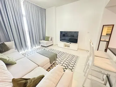 a living room with two beds and a tv at Dubai damac hills luxurious appartment in Dubai
