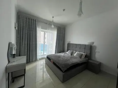 a bedroom with a bed and a large window at Opal Tower in Dubai