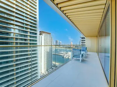 a balcony with a blue bench and a view of the water at Exclusive Beachfront 2 Bed with Pool & Palm View in Dubai