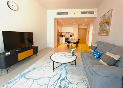 a living room with a couch and a tv at Stunning 1BR Apartment High floor Creek Harbour in Dubai