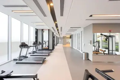 a row of treadmills in a gym with windows at Stunning 1BR Apartment High floor Creek Harbour in Dubai