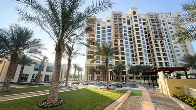 a resort with palm trees in front of a building at Marina Haven I Waterfront I Pool I Gym and Sauna in Dubai