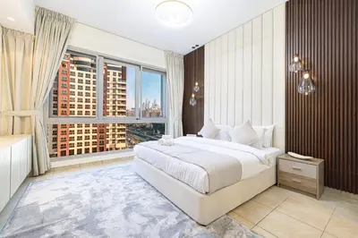 a bedroom with a large bed and a large window at Marina Haven I Waterfront I Pool I Gym and Sauna in Dubai