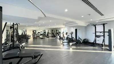 a gym with several tread machines and people in it at Marina Haven I Waterfront I Pool I Gym and Sauna in Dubai