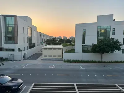 a parking lot with a car parked in front of buildings at Luxurious Meydan Dubai 6 BED Villa Unparalleled Views in Dubai